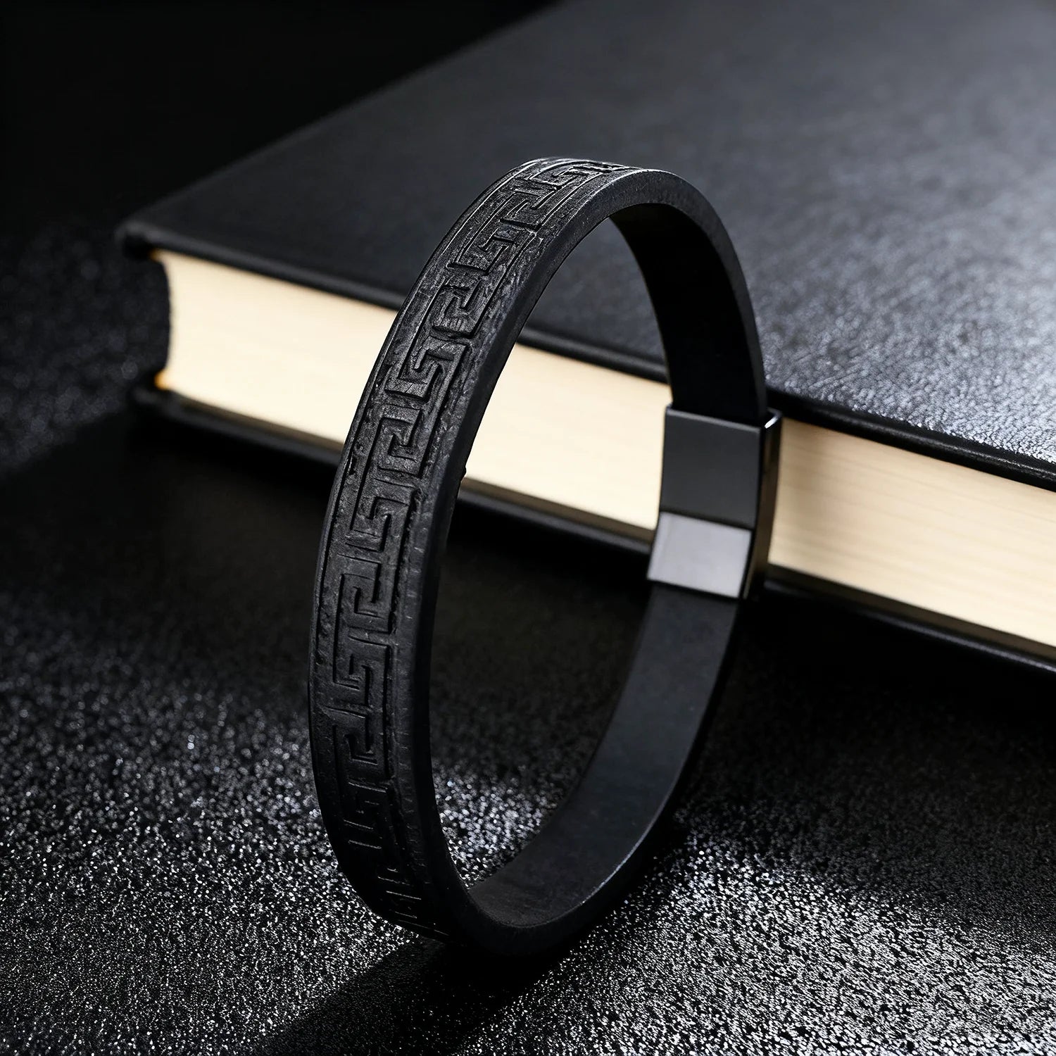 Black bracelet with intricate design on a textured surface