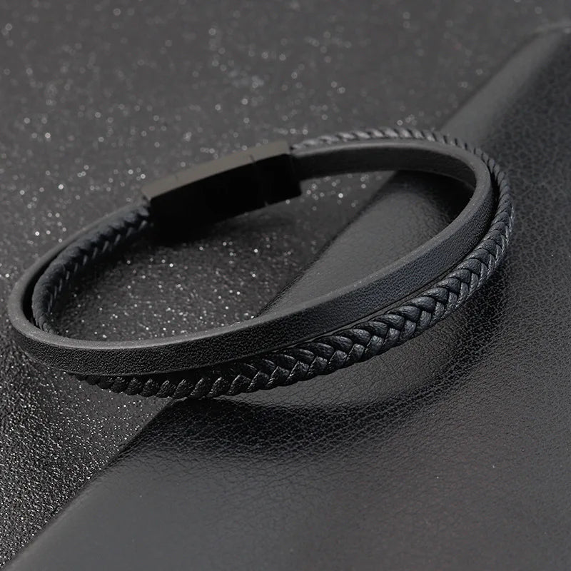 Black braided leather bracelet on a textured black surface
