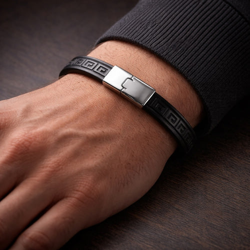 Black bracelet with a silver clasp on a wrist against a dark background