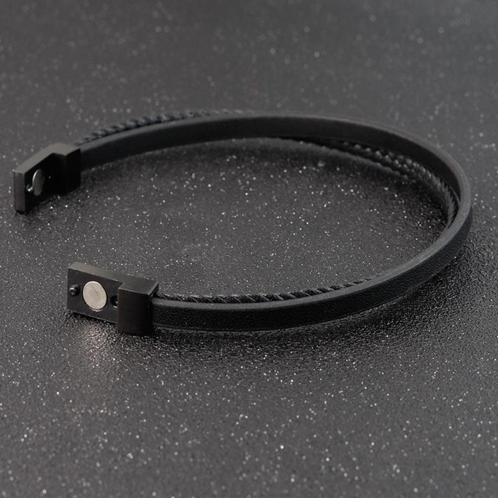 Black leather bracelet on a dark textured surface